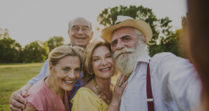 group of happy seniors huddled together for an outdoor photo