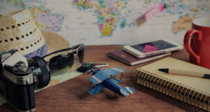 collection of items suggesting travel, camera, passport, toy plane..