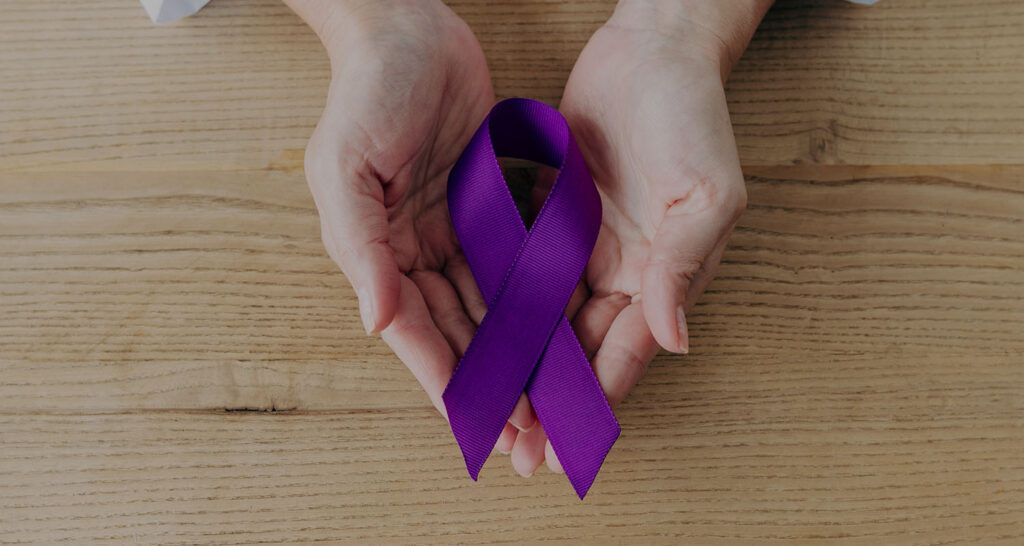 hands cupping a purple ribbon representing dementia support