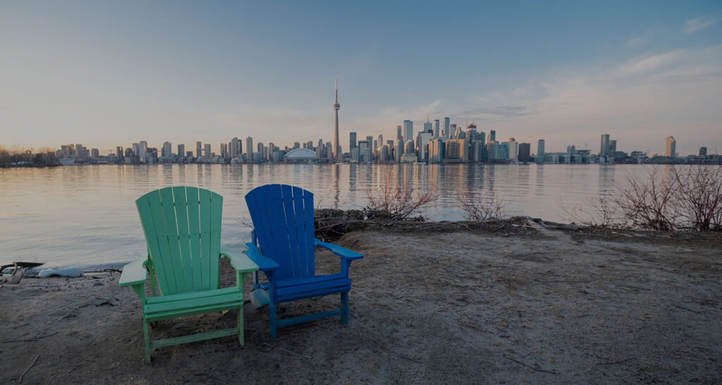 Two muskoka chairs looking across to Toronto downtown city scape