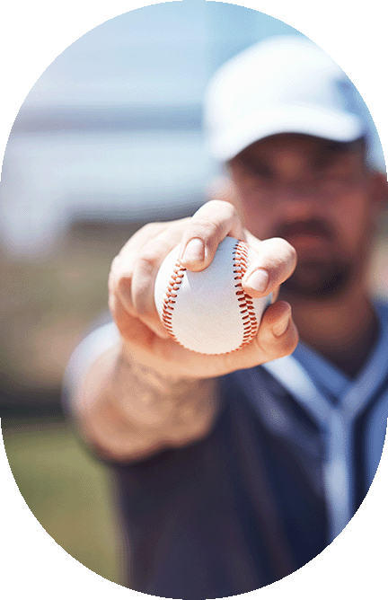 baseball in forground man holding it in background is blurry