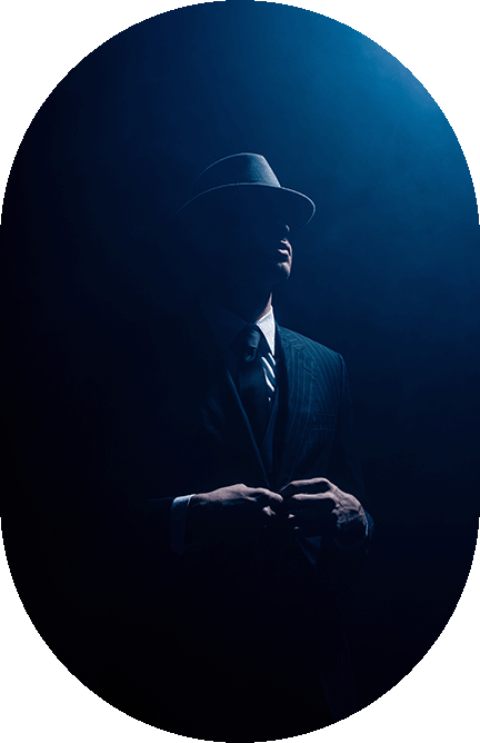 40's era man in silouette with fedora hat and spot light down form above