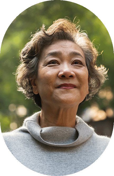 Elderly asian woman in soft sweater outdoors.