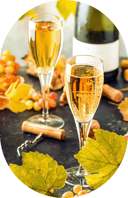 Two glasses of sparkling wine with bubbles, surrounded by yellow grape leaves, grapes, a corkscrew, wine corks, and a wine bottle in the background—capturing the vibrant spirit of waterfront community activities at The Shores of Port Credit.